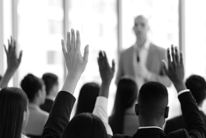 Audience raised hands listening to speaker